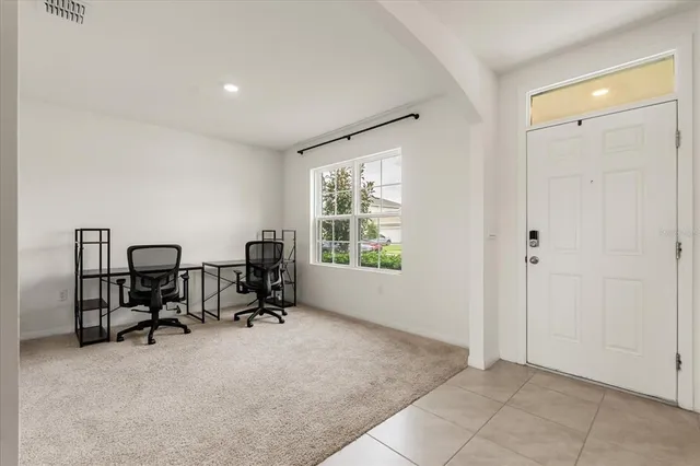 a view of a workspace with furniture and a window