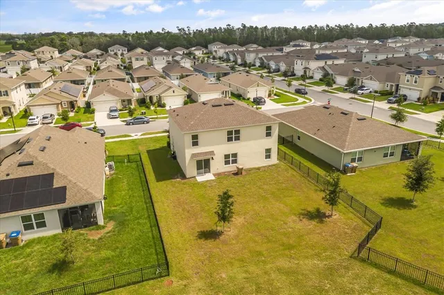 an aerial view of residential houses with yard