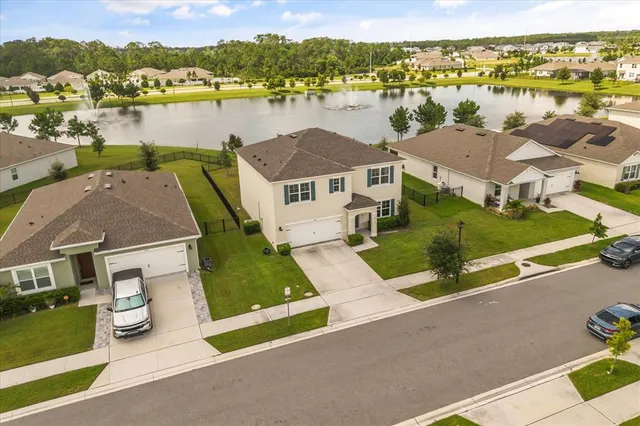 an aerial view of a house with outdoor space and lake view