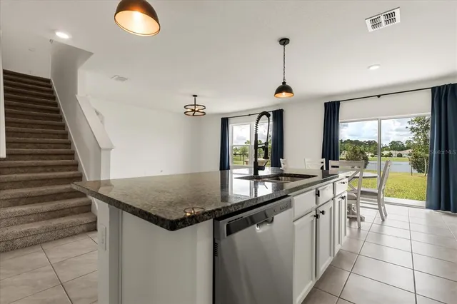 a kitchen with stainless steel appliances granite countertop a sink and a refrigerator