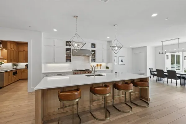 a kitchen with stainless steel appliances kitchen island granite countertop a table and chairs in it
