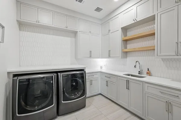a utility room with sink dryer and washer