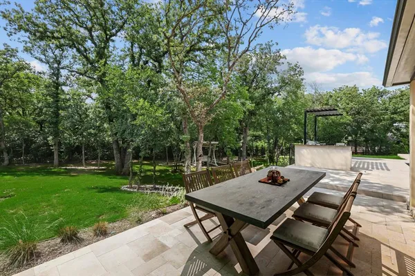 a view of a backyard with table and chairs and potted plants