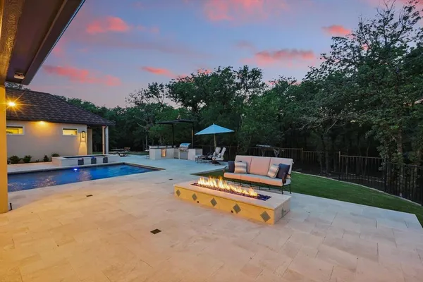 a view of a swimming pool with a bench and trees in the background