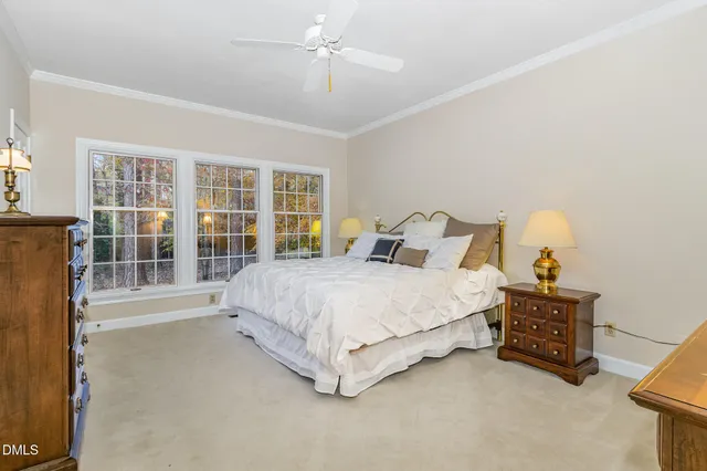 a bedroom with a bed lamp and a large window