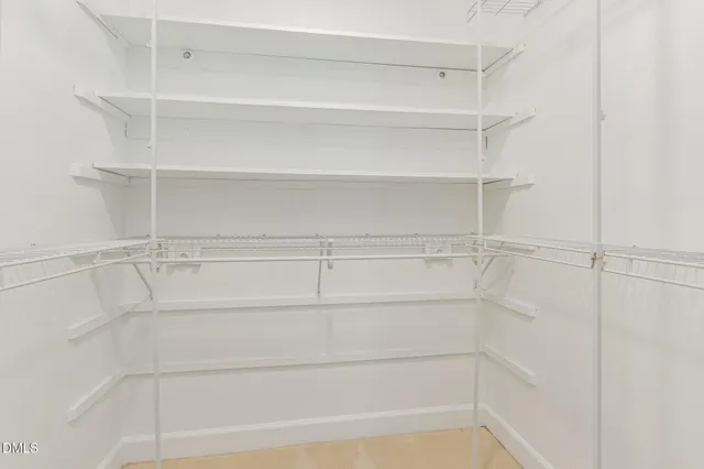 a view of walk in closet with empty racks