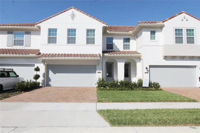 a view of white house with a yard and potted plants