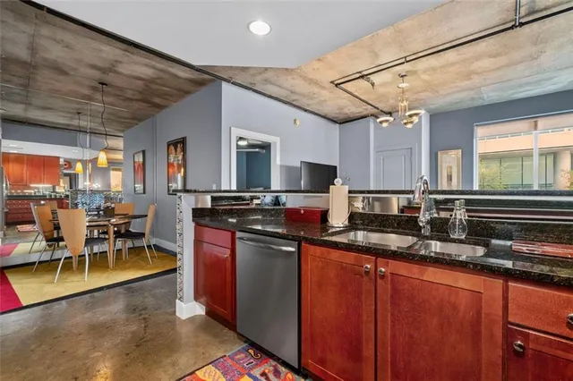 a kitchen with stainless steel appliances granite countertop sink stove top oven and cabinets