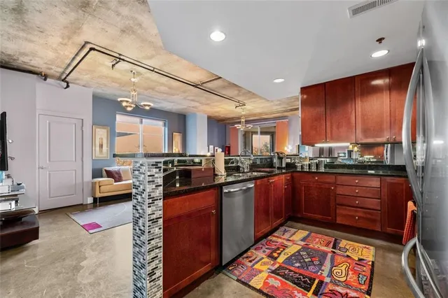 a kitchen with stainless steel appliances granite countertop sink stove and cabinets
