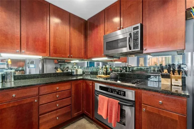 a kitchen with stainless steel appliances granite countertop a stove and a microwave