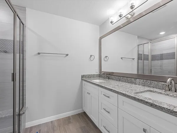 a bathroom with a granite countertop sink and a mirror