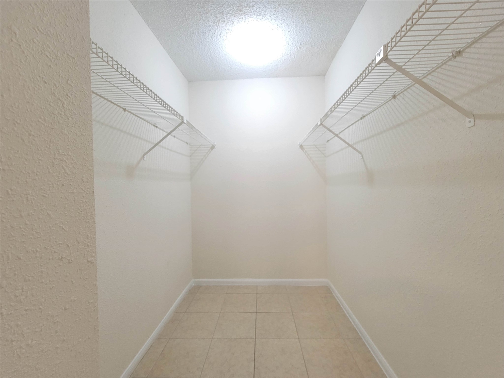 8706 Schick Road, Unit A Austin, TX 78729 - Photo 25 of 33 A well-organized walk-in closet offers ample storage with practical wire shelving and tiled flooring.