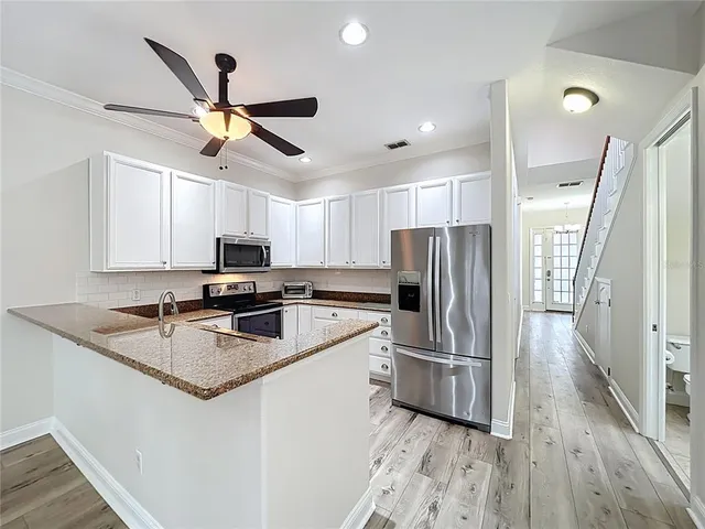 a view of a hallway with wooden floor and staircase
