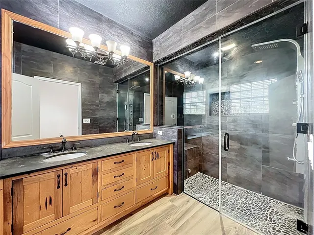 a bathroom with a sink a toilet a mirror and shower