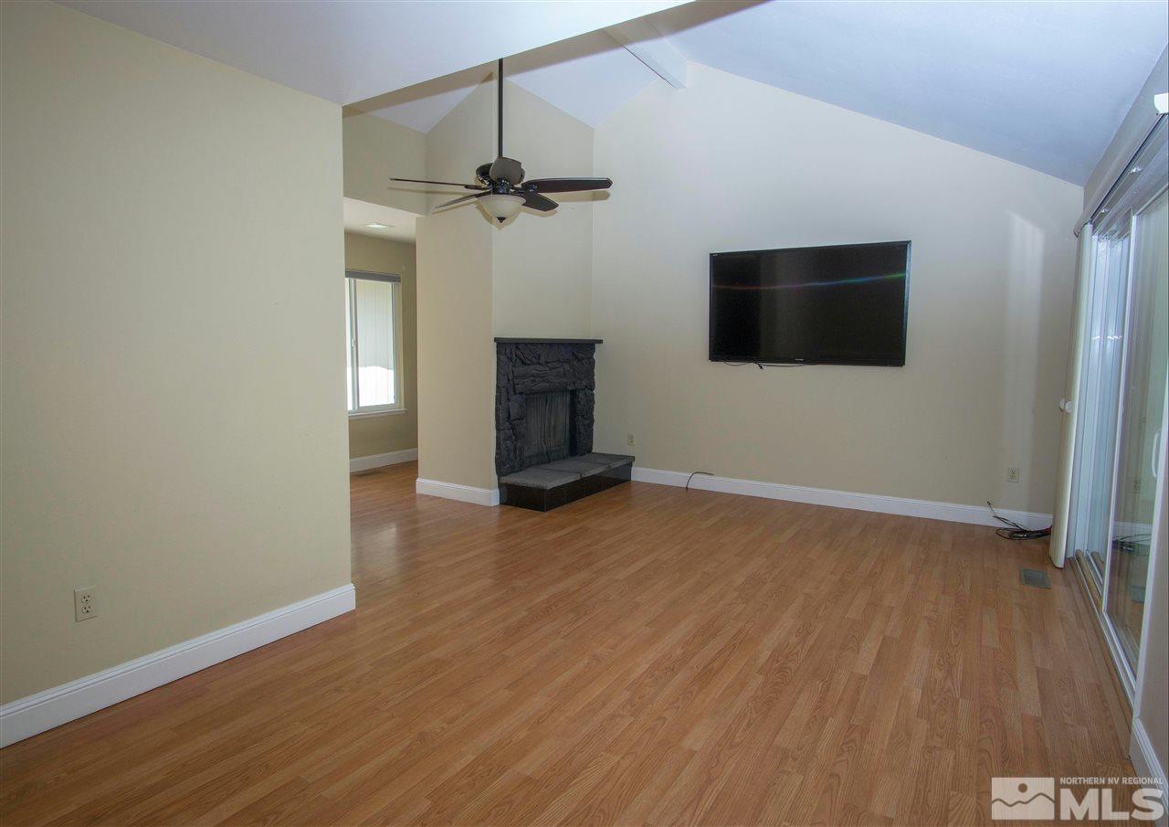 1245 Searchlite Court Reno, NV 89503 - Photo 7 of 26 a view of a livingroom with wooden floor a flat screen tv and staircase
