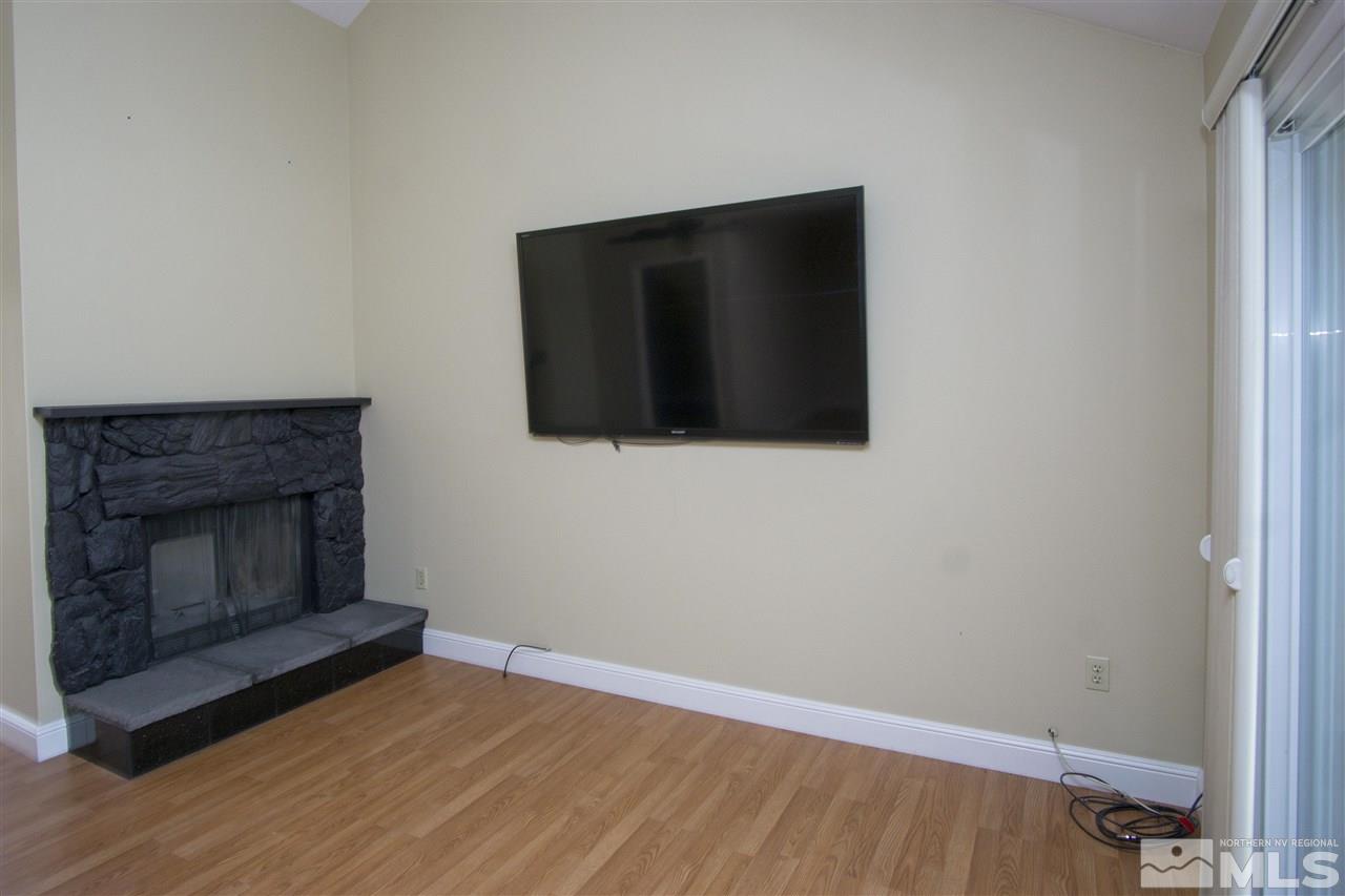 1245 Searchlite Court Reno, NV 89503 - Photo 8 of 26 a living room with a fireplace and a flat screen tv