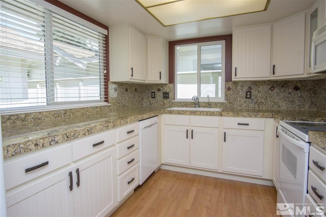 1245 Searchlite Court Reno, NV 89503 - Photo 10 of 26 a kitchen with granite countertop white cabinets and a window