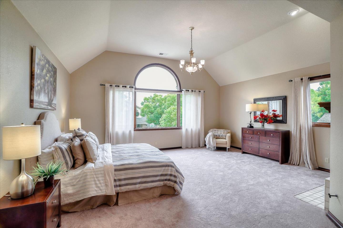 669 Regas Drive Campbell, CA 95008 - Photo 23 of 59 a spacious bedroom with a bed and a chandelier