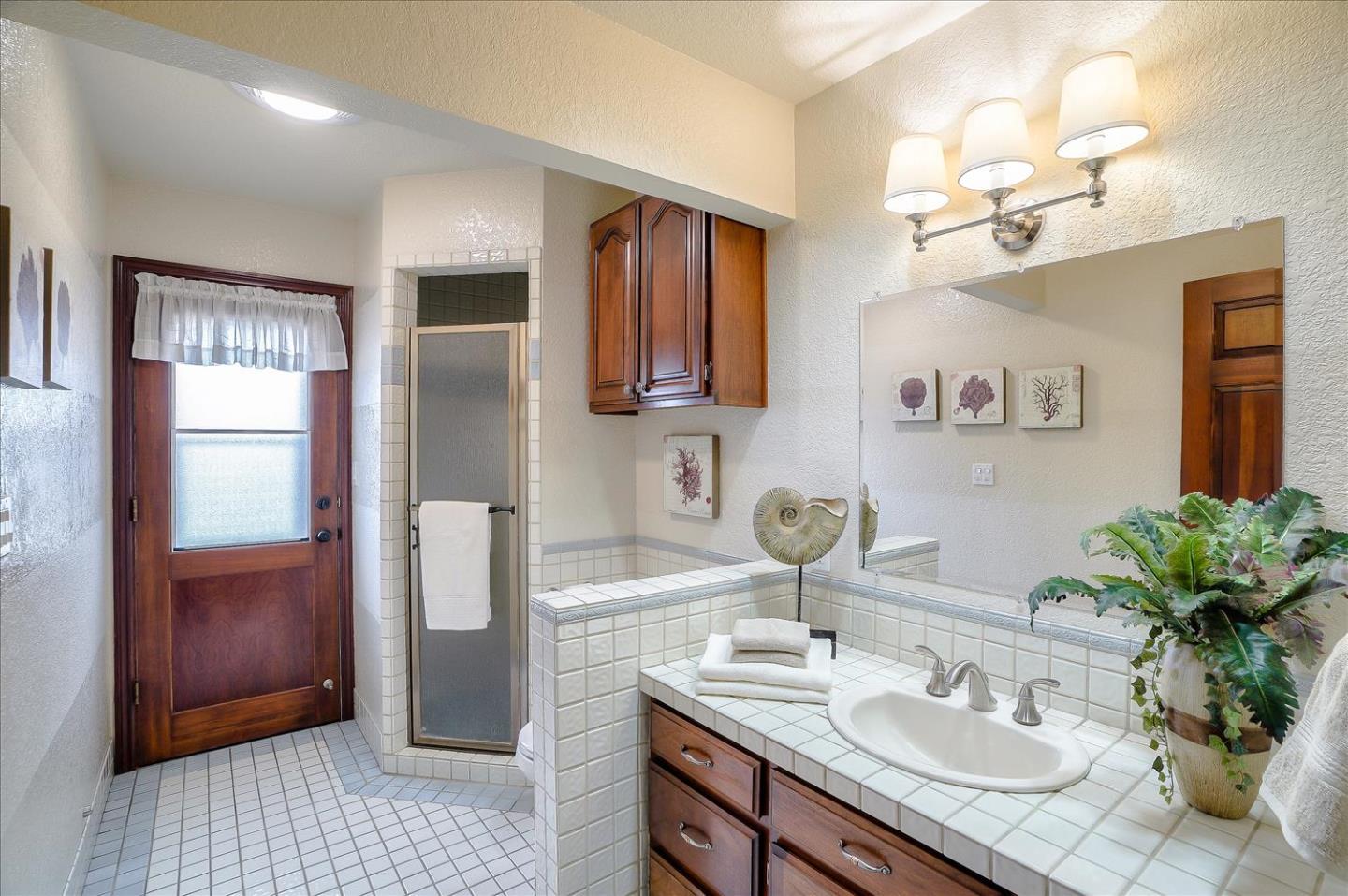 669 Regas Drive Campbell, CA 95008 - Photo 48 of 59 a bathroom with a granite countertop sink a mirror and a shower