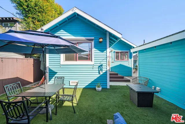 a view of house with backyard and outdoor seating