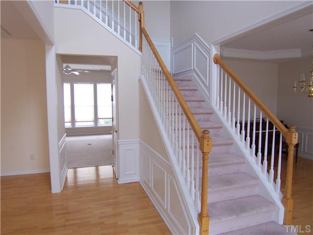 7605 Derek Drive Raleigh, NC 27613 - Photo 2 of 18 a view of a hallway with wooden floor and stairs