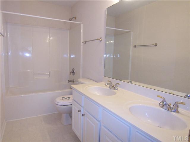7605 Derek Drive Raleigh, NC 27613 - Photo 11 of 18 a bathroom with a granite countertop sink a toilet and shower