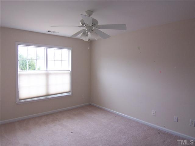 7605 Derek Drive Raleigh, NC 27613 - Photo 9 of 18 an empty room with a window and a fan