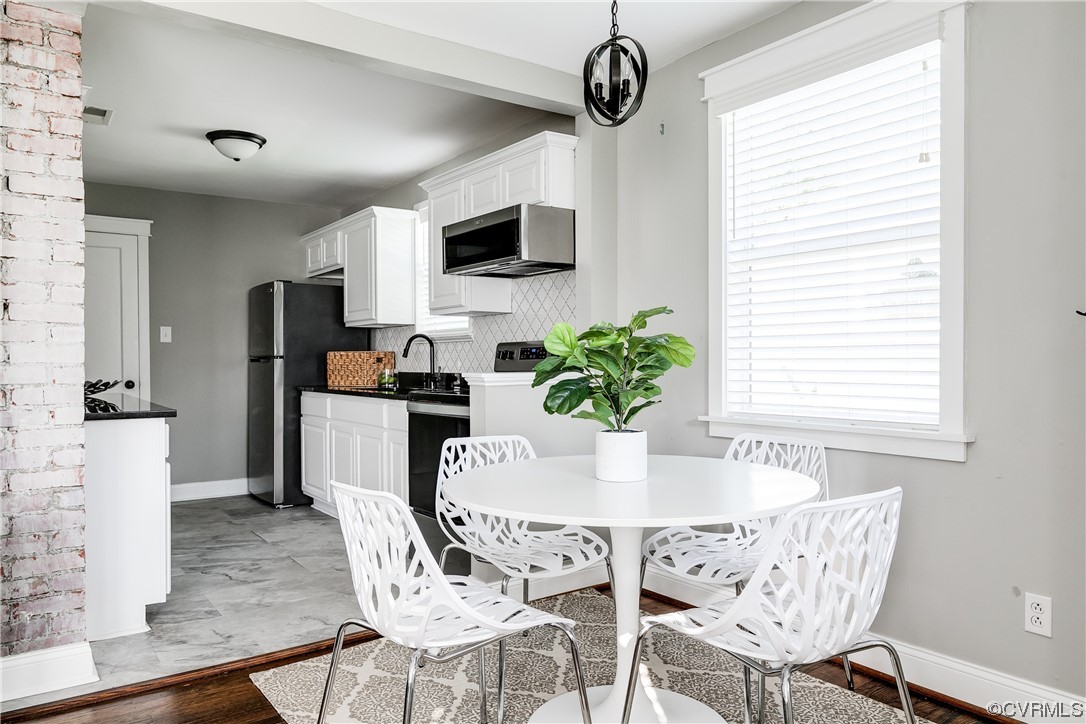 4301 Norborne Road Richmond, VA 23234 - Photo 4 of 29 a dining room with furniture a window and stainless steel appliances