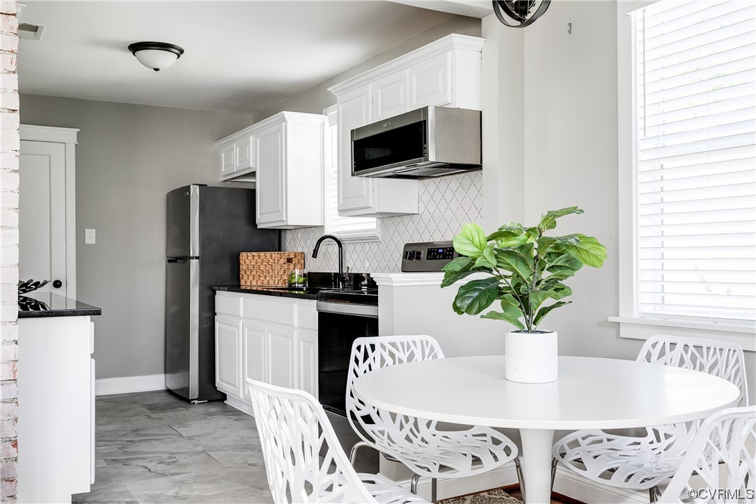 4301 Norborne Road Richmond, VA 23234 - Photo 5 of 29 a dining room with furniture a potted plant and a kitchen view