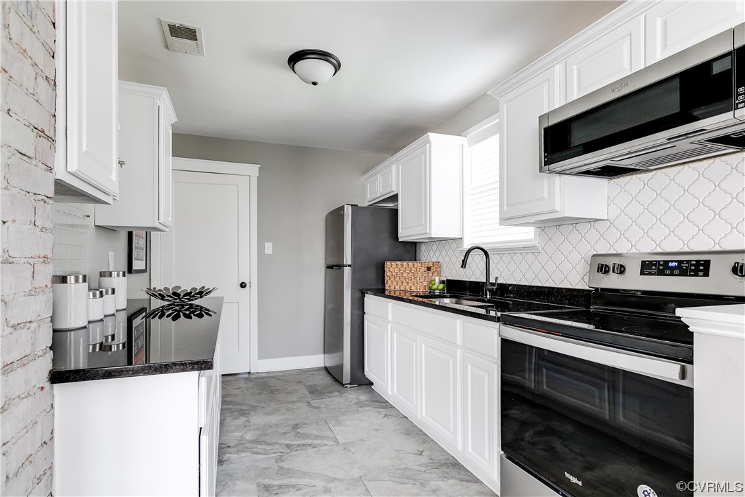 4301 Norborne Road Richmond, VA 23234 - Photo 6 of 29 a kitchen with stainless steel appliances a stove sink microwave and cabinets