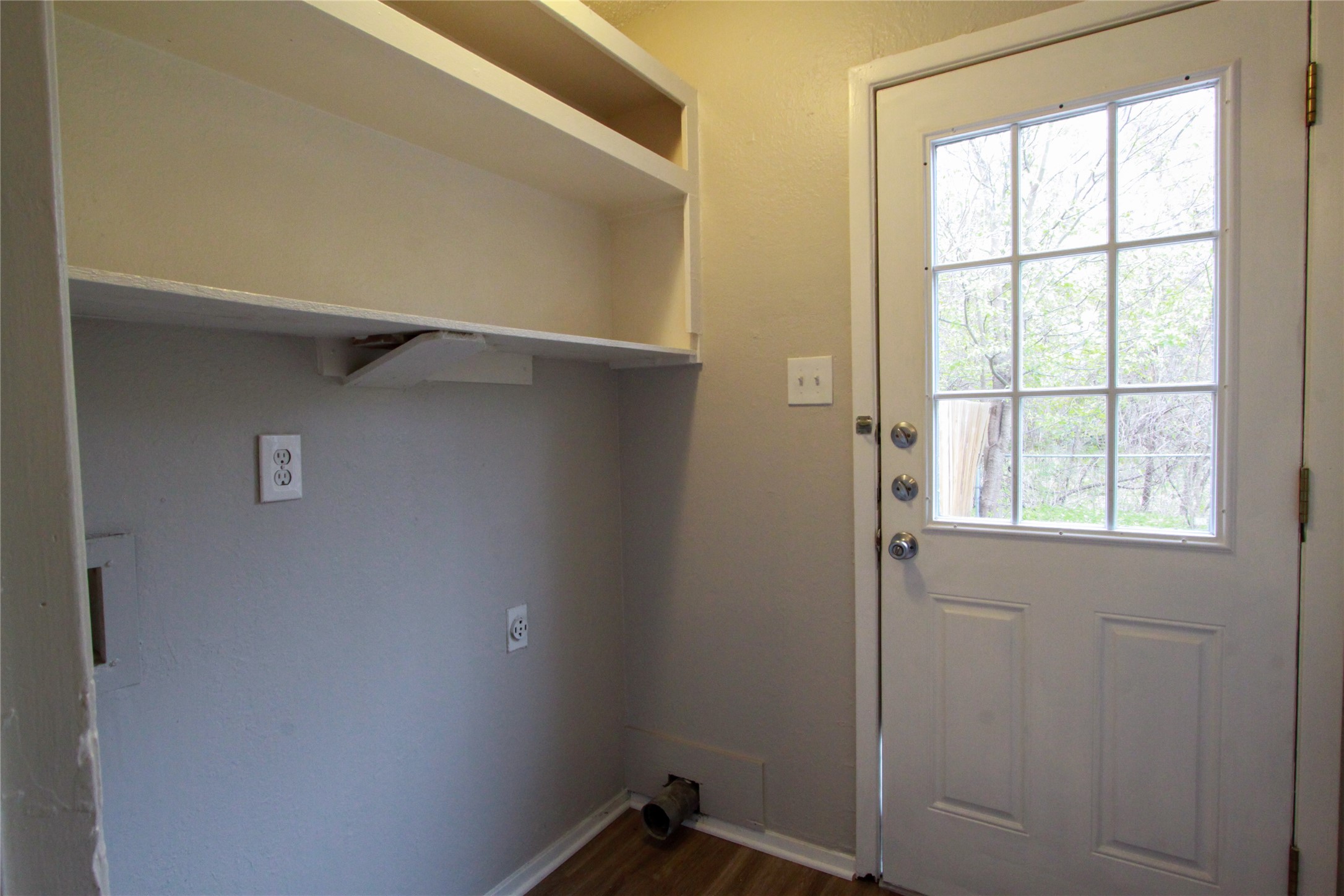 12609 Turtle Rock Road, Unit A Austin, TX 78729 - Photo 7 of 22 Functional utility space includes built-in upper shelving and direct exterior access.