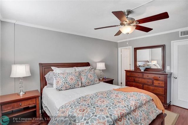 a bedroom with a bed and a lamp on dresser