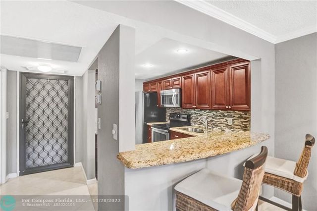 a kitchen with kitchen island granite countertop wooden cabinets and a granite counter tops