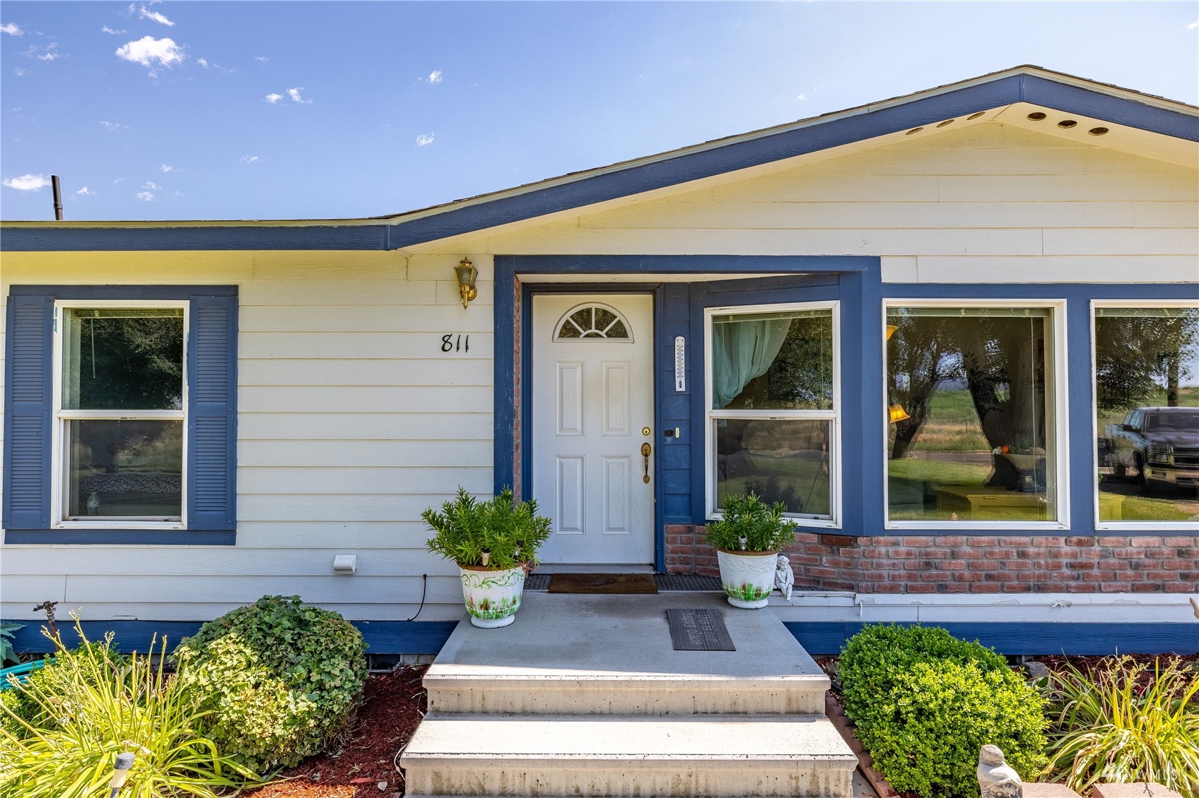 811 South Steele Road Othello, WA 99344 - Photo 3 of 40 a front view of a house with potted plants