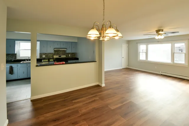 a view of a kitchen with a stove wooden floor and a chandelier