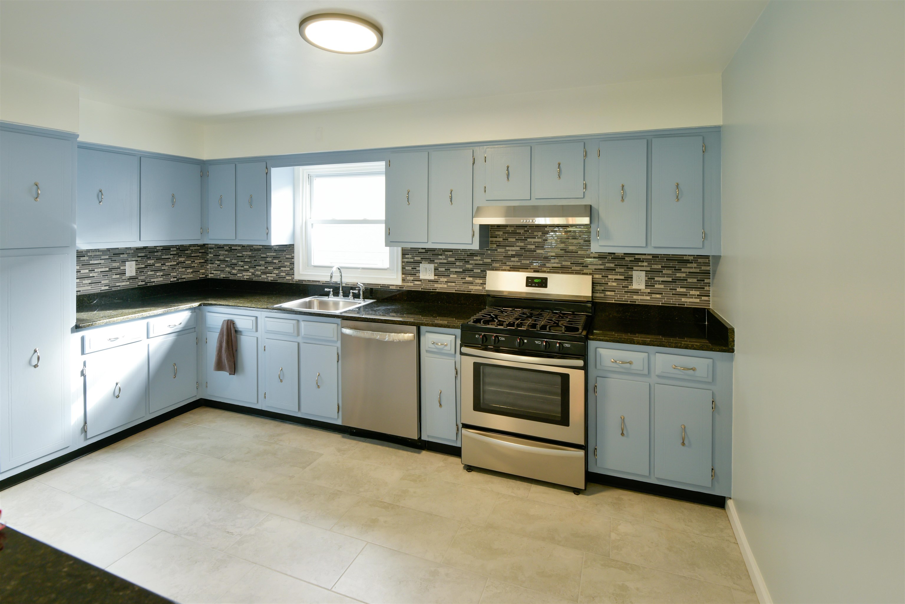 45 East 51st Street Bayonne, NJ 07002 - Photo 7 of 26 a kitchen with stainless steel appliances a stove a sink a microwave and cabinets