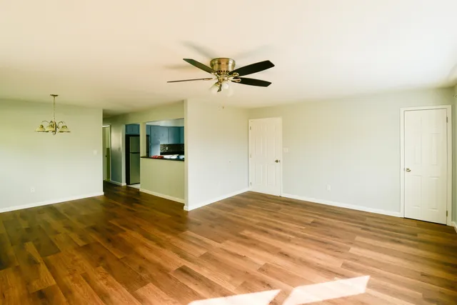 a view of a kitchen with wooden floor and a ceiling fan