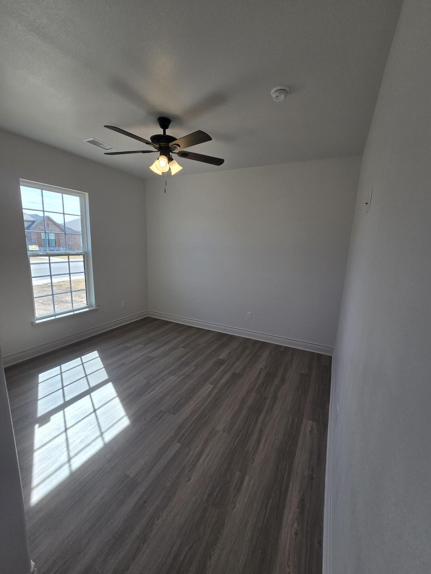 7814 53rd Street Lubbock, TX 79407 - Photo 11 of 24 an empty room with windows and fan