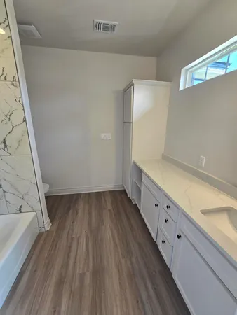 a view of an empty room with wooden floor