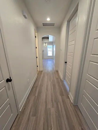 a view of a hallway with wooden floor and staircase