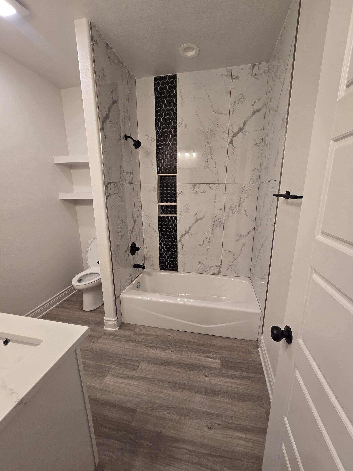 7814 53rd Street Lubbock, TX 79407 - Photo 14 of 24 a bathroom with a bathtub and a shower