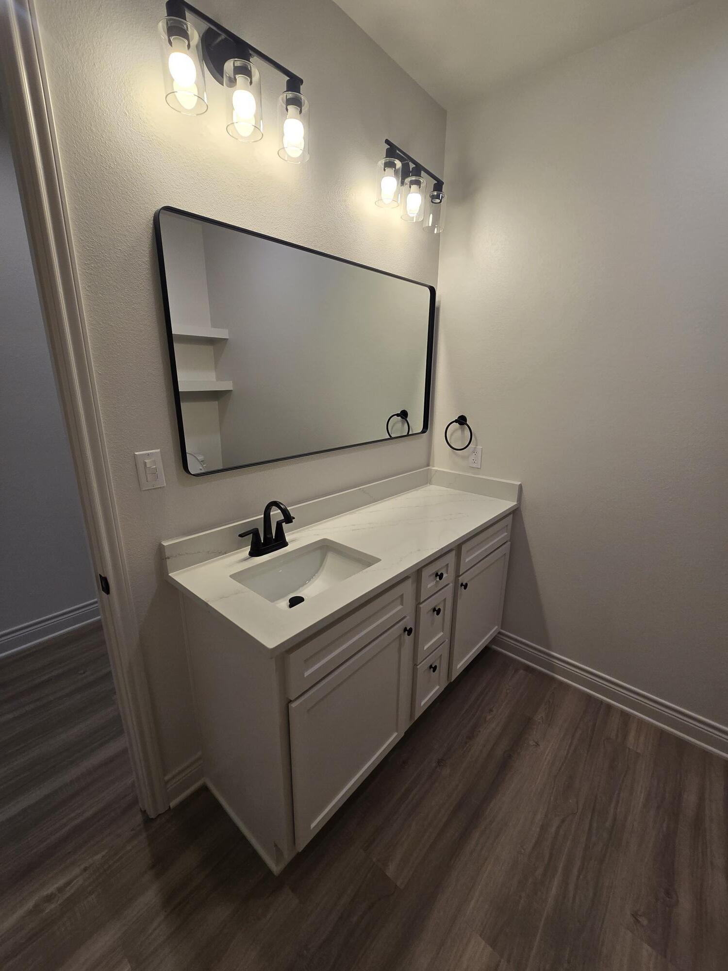 7814 53rd Street Lubbock, TX 79407 - Photo 15 of 24 a utility room with a sink and mirror