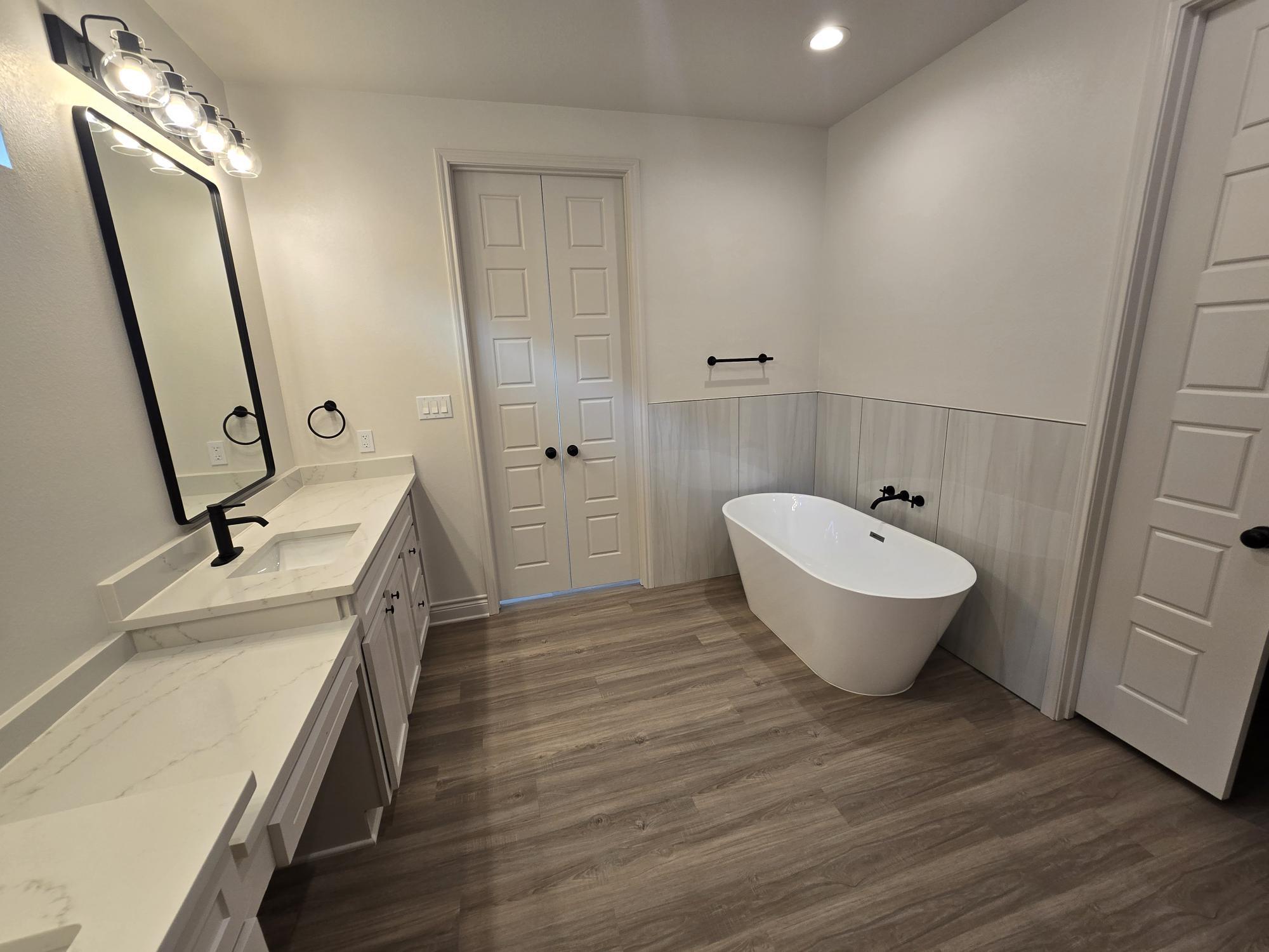 7814 53rd Street Lubbock, TX 79407 - Photo 17 of 24 a spacious bathroom with a bathtub and a sink