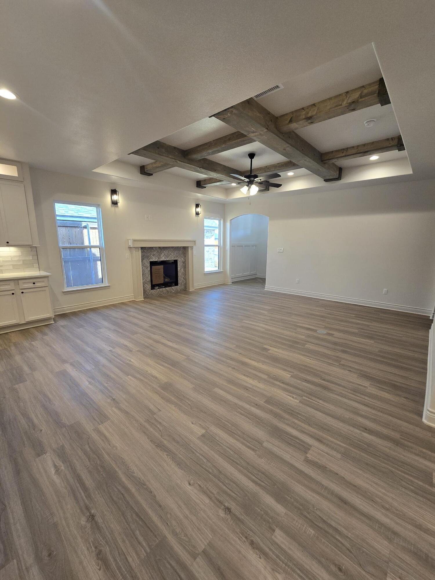 7814 53rd Street Lubbock, TX 79407 - Photo 2 of 24 an empty room with wooden floor fireplace and windows