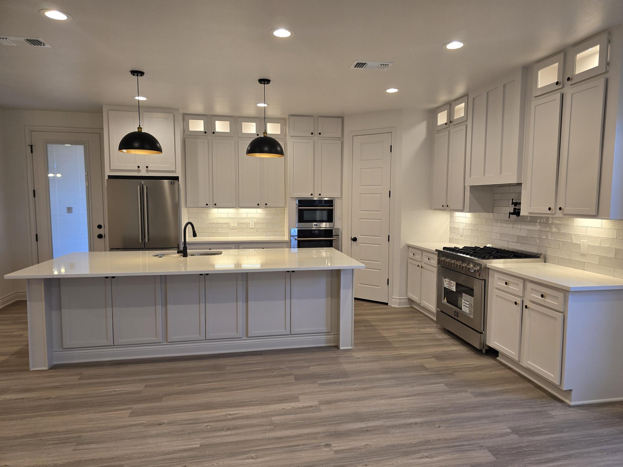 7814 53rd Street Lubbock, TX 79407 - Photo 3 of 24 a large kitchen with stainless steel appliances granite countertop a stove a sink and a refrigerator
