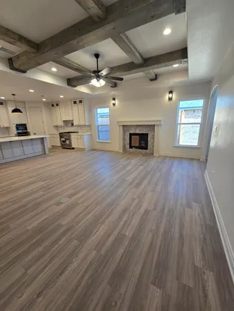 a view of a room with wooden floor fireplace and window