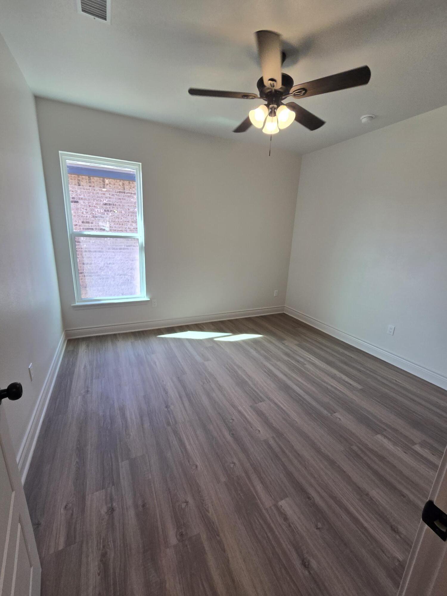 7814 53rd Street Lubbock, TX 79407 - Photo 6 of 24 wooden floor in an empty room with a window