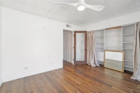 an empty room with wooden floor and closet