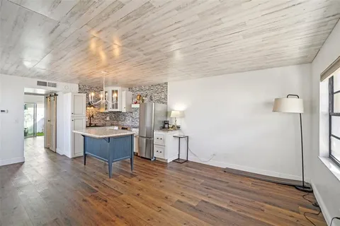 a kitchen with a wooden floor and cabinets