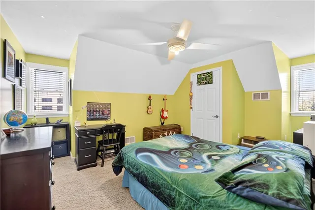 a bedroom with a bed and dresser with mirror